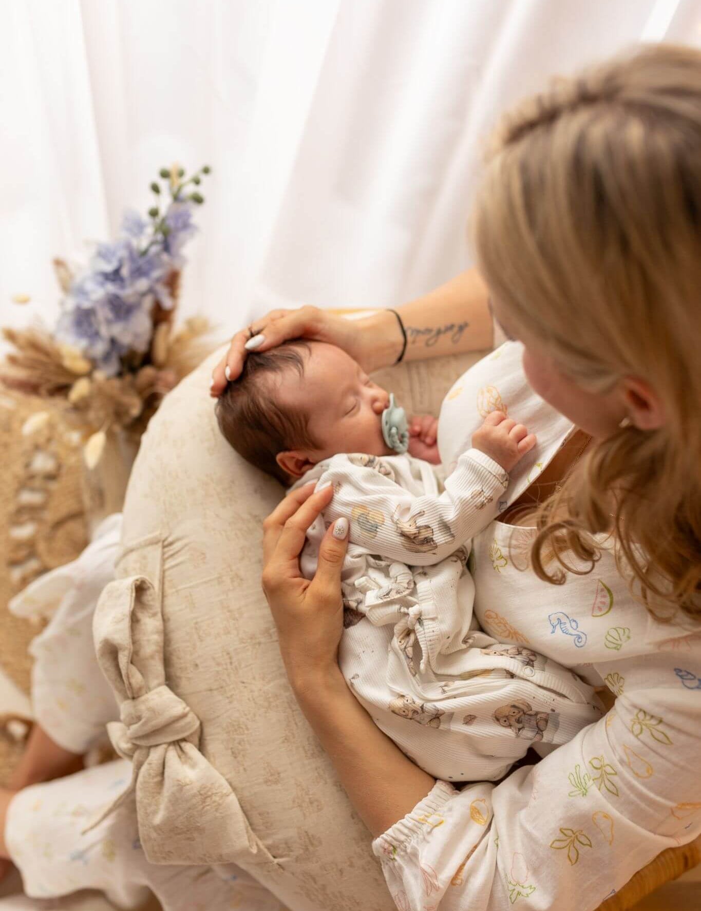 Woman holding a baby on a cushion with a soft, blurred background