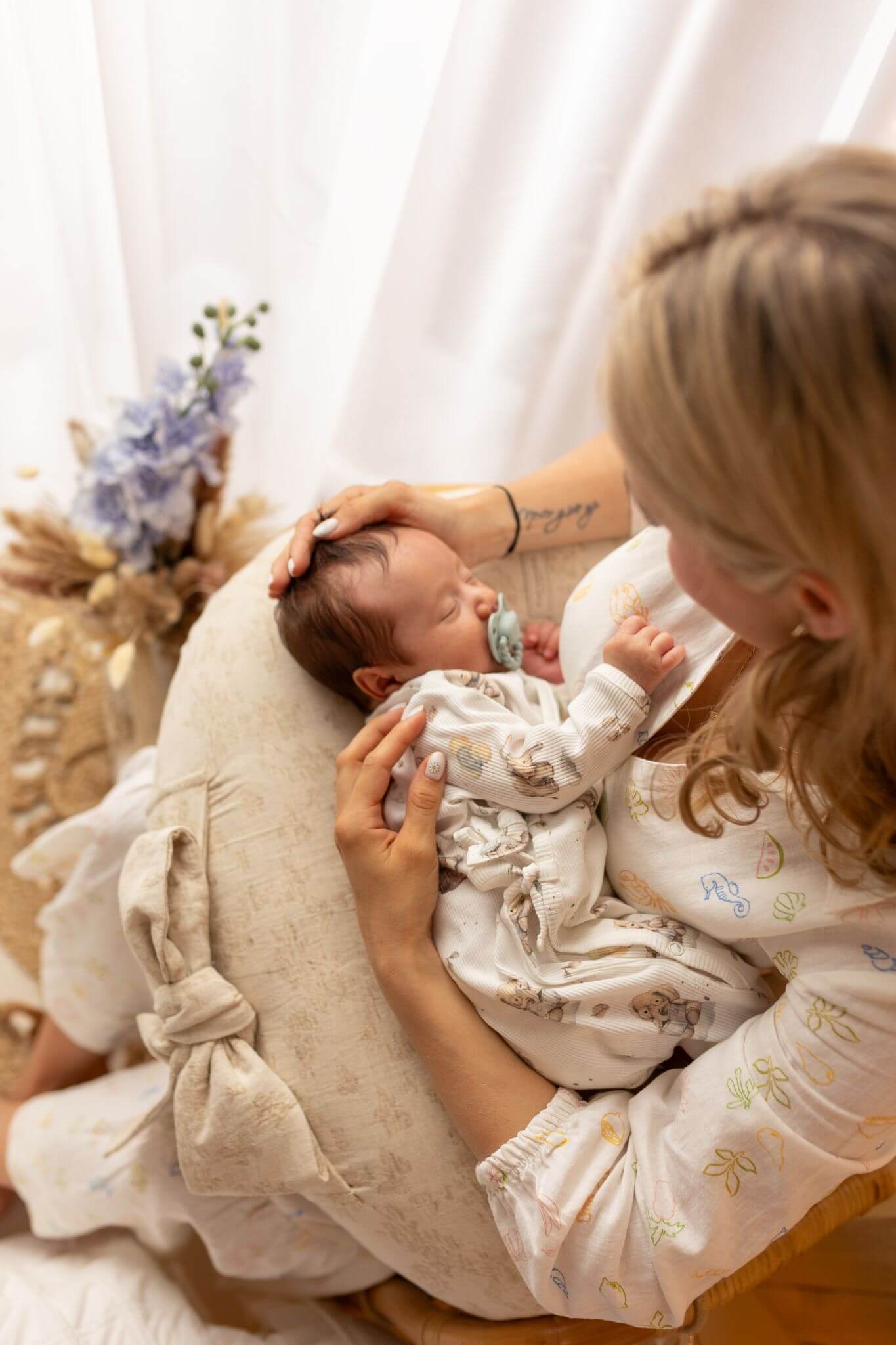Woman holding a baby on a cushion with a soft, blurred background
